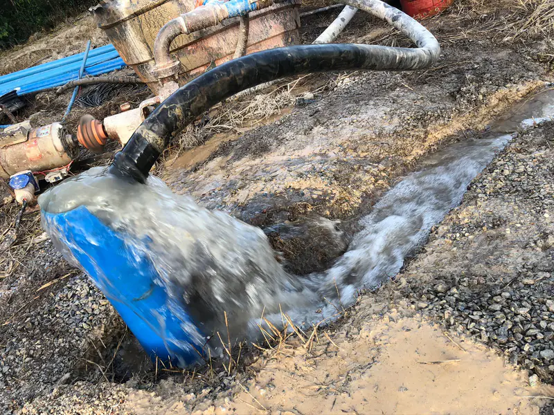 Descarga de água junto ao revestimento azul de um poço